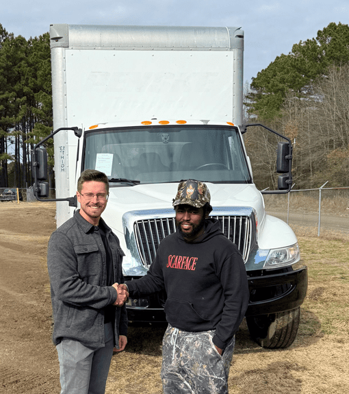 Owner with purchaser standing in front of a white commercial box truck at US Truck & Body LLC.