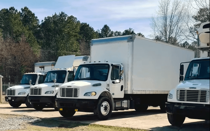 Line of white commercial box trucks available for sale at US Truck & Body LLC