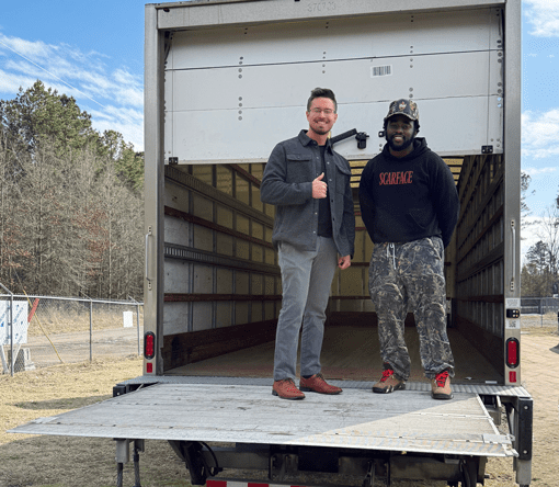 Owner with purchaser standing in front of a white commercial box truck at US Truck & Body LLC